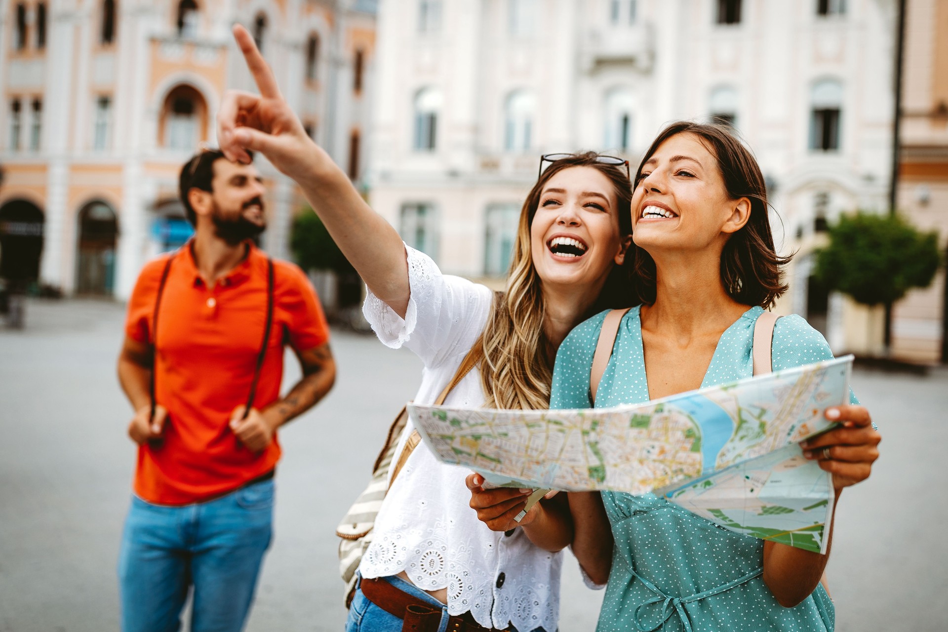 Happy traveling tourists sightseeing with map in hand