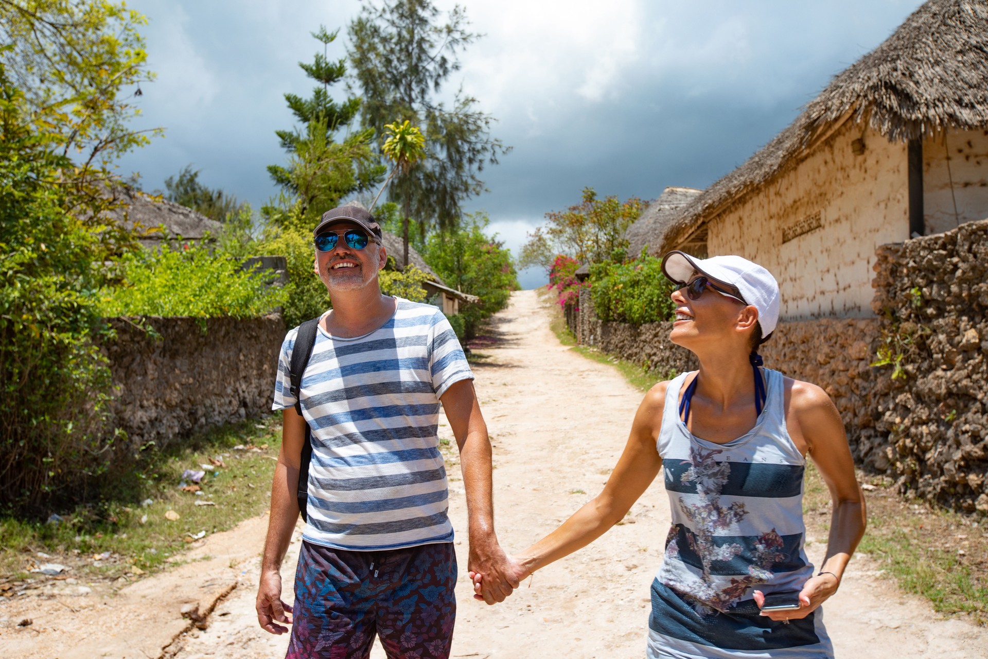 Smiling Mid Adult Couple Holding Hands and Exploring African Village